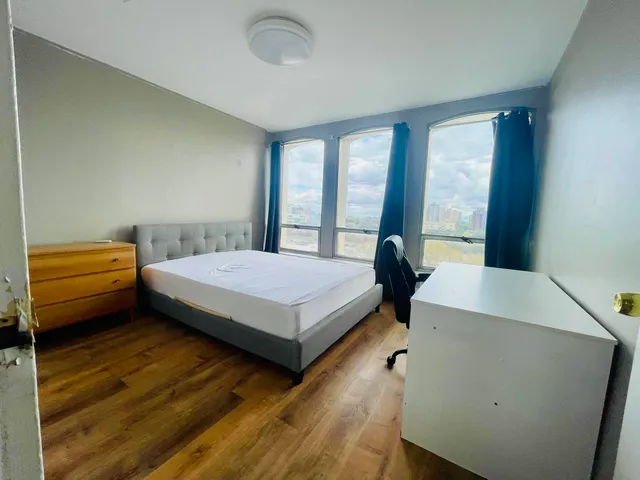 a bedroom with a bed and a large window