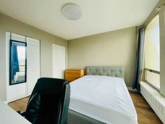 a bed sitting in a bedroom next to a window