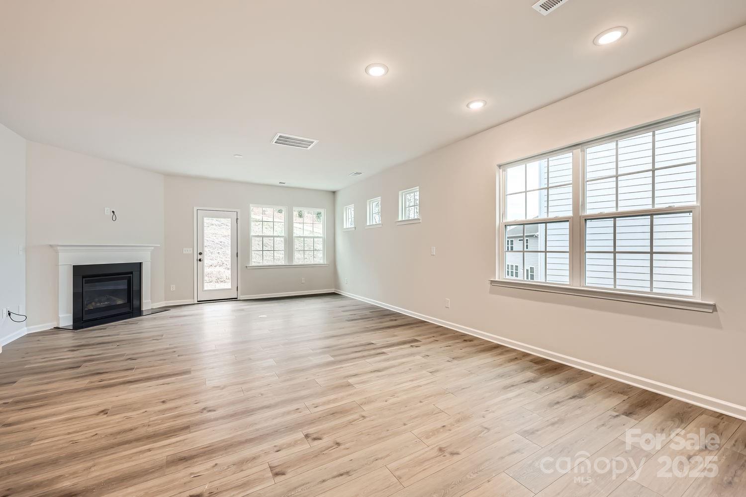 5720 Olive Bch Road Kannapolis, NC 28081 - Photo 4 of 13 an empty room with wooden floor and fireplace