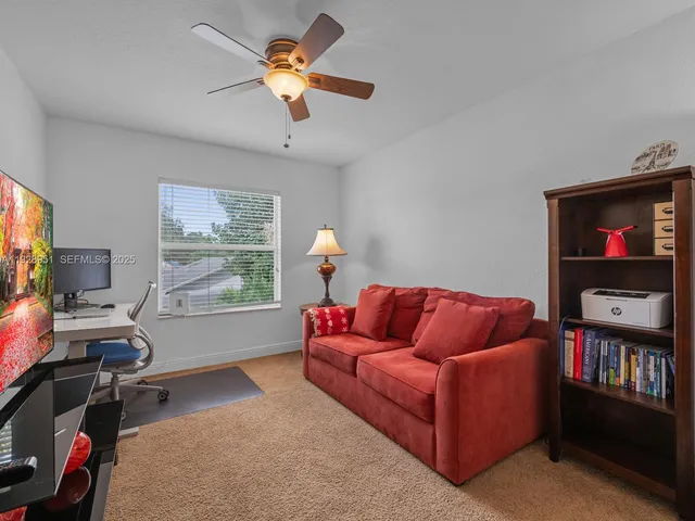 a living room with furniture a flat screen tv and a window