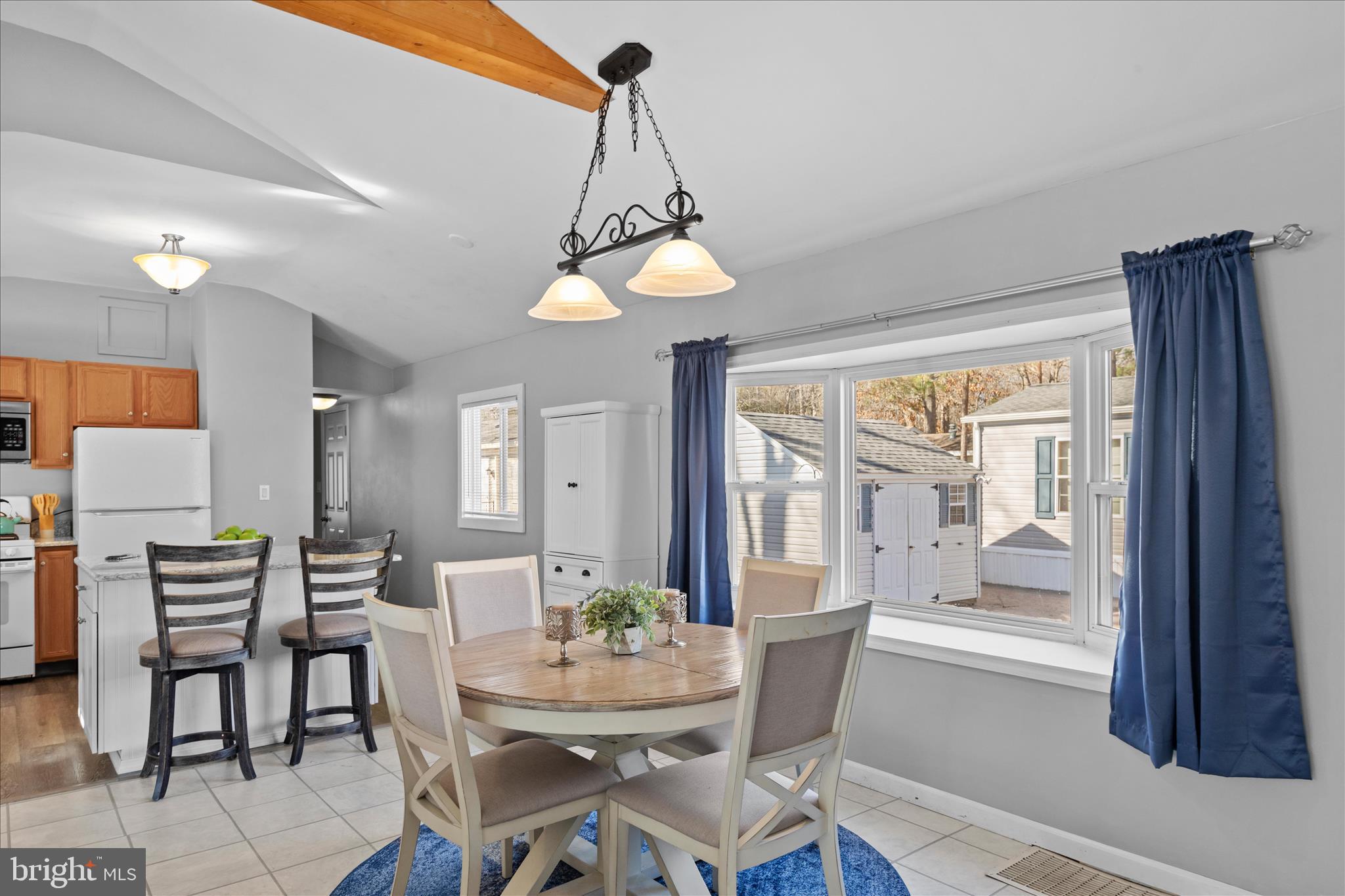 25760 Blue Ridge Street Millsboro, DE 19966 - Photo 12 of 64 a dining room with wooden floor a chandelier a wooden table and chairs
