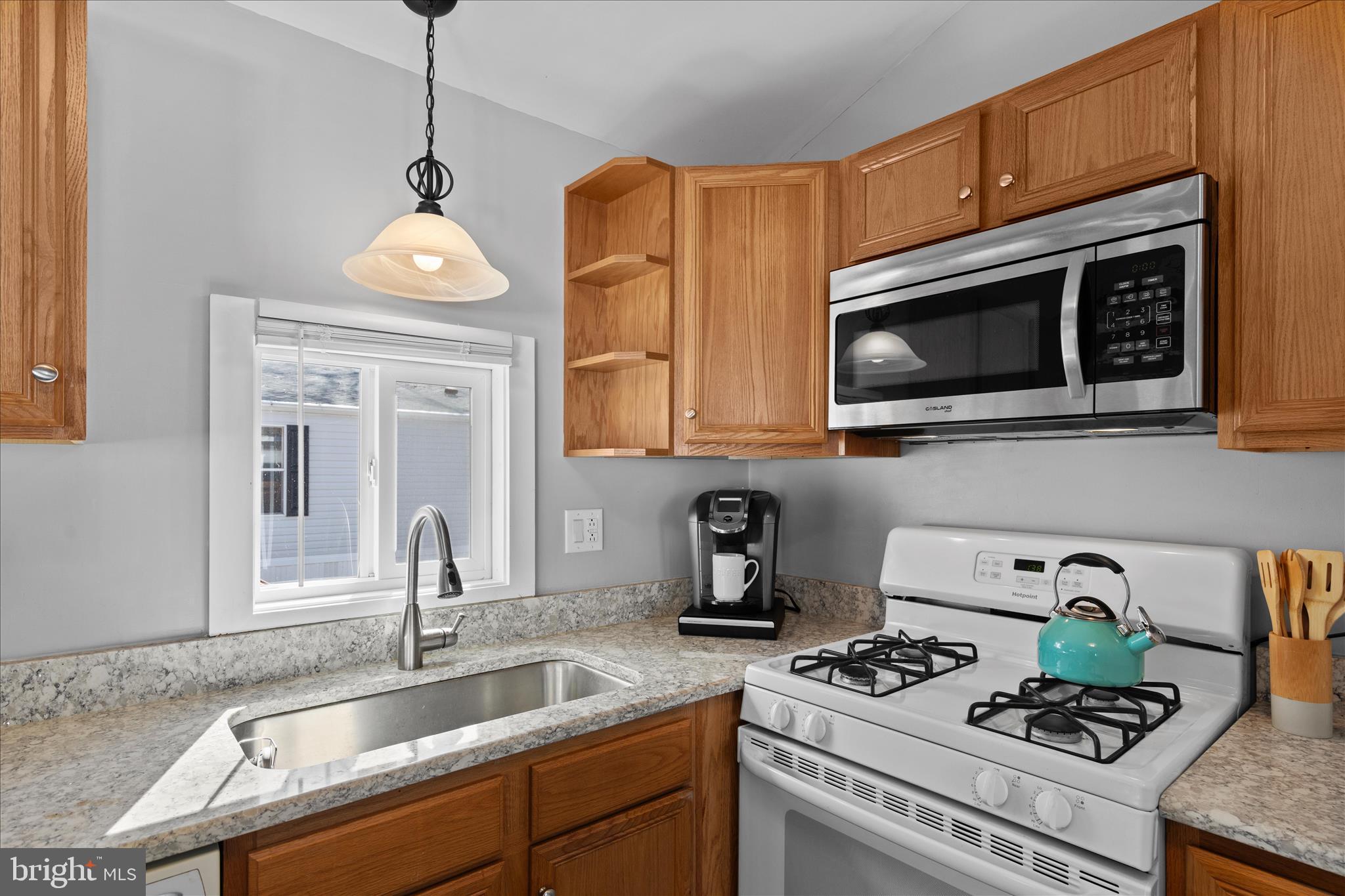 25760 Blue Ridge Street Millsboro, DE 19966 - Photo 21 of 64 a kitchen with stainless steel appliances granite countertop a sink a stove and a microwave