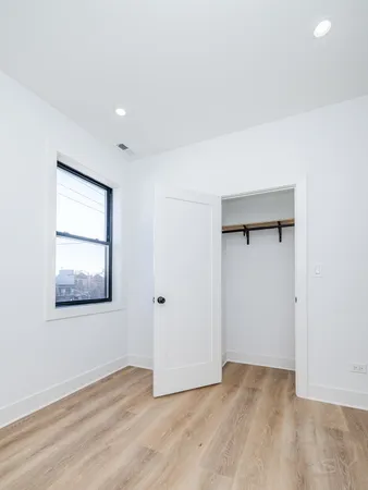 an empty room with wooden floor and a window