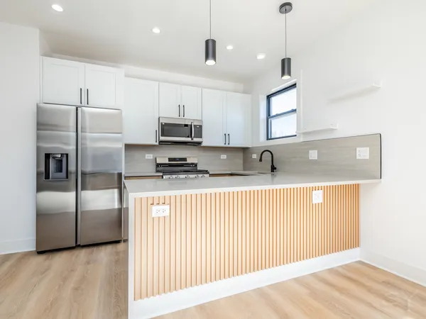 a kitchen with stainless steel appliances granite countertop a refrigerator a sink and a stove