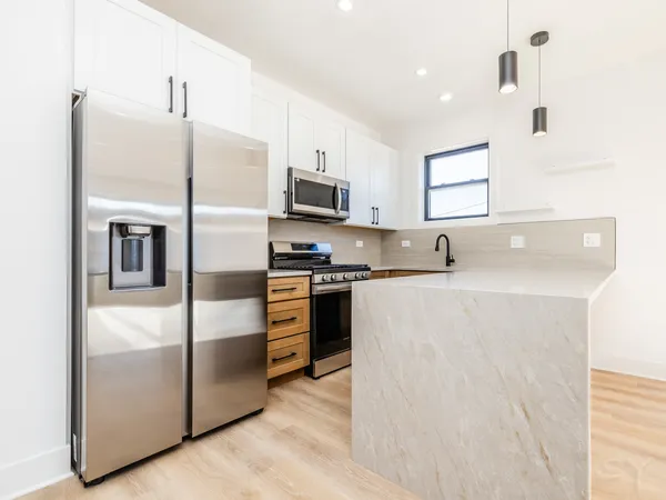 a kitchen with stainless steel appliances a refrigerator sink and microwave