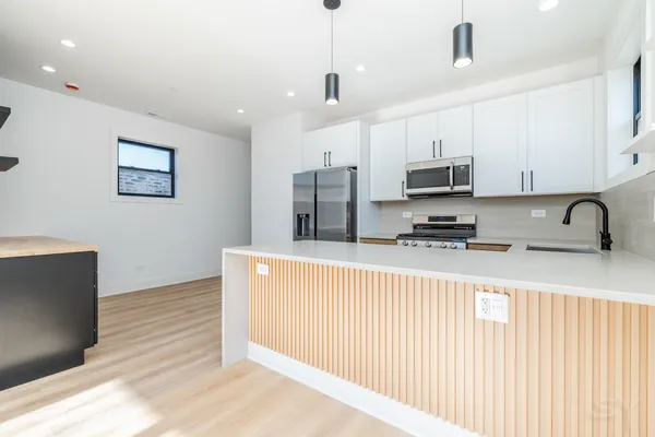 a kitchen with kitchen island a stove a sink and a refrigerator