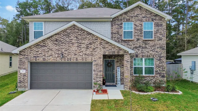 a front view of a house with a garden and yard