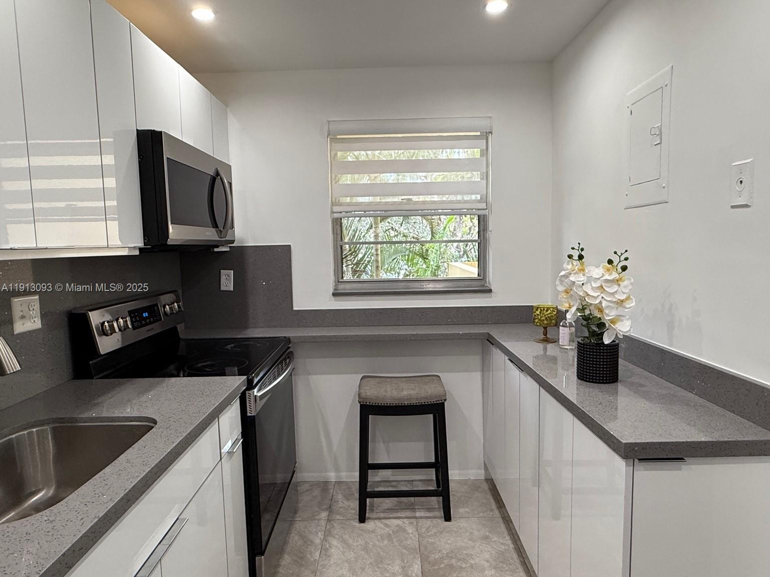 3490 Foxcroft Road, Unit B208 Miramar, FL 33025 - Photo 25 of 32 a kitchen with a sink stove and microwave