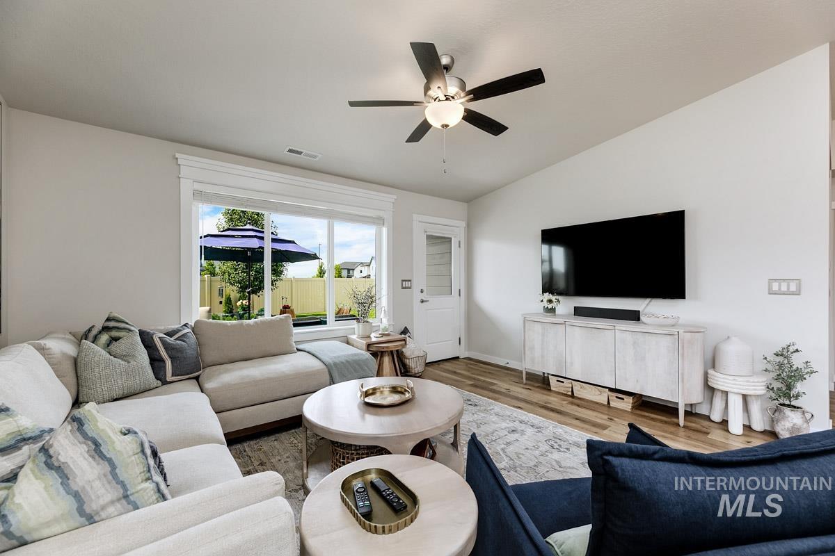 348 West Radiant Rdg Drive Meridian, ID 83642 - Photo 12 of 36 Wood-finish flooring, ceiling fan with integrated lighting, built-in entertainment console, and glass-paneled exterior door