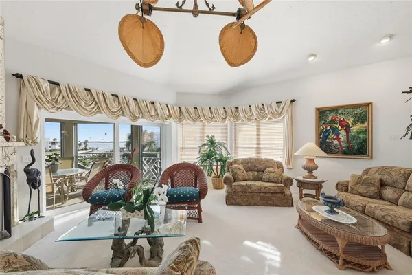 a living room with furniture a dining table and a floor to ceiling window