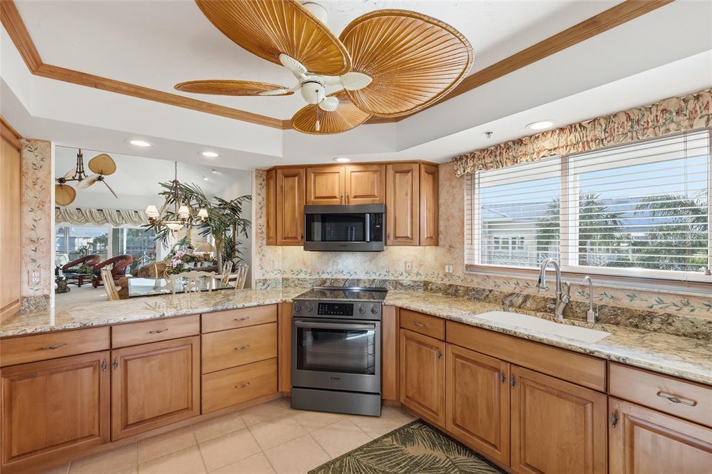 11000 Placida Road, Unit 1504 Placida, FL 33946 - Photo 10 of 73 a kitchen with stainless steel appliances granite countertop a sink a stove and cabinets