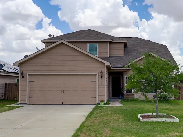 a view of a house with backyard and a tree