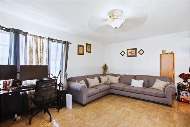 a living room with furniture ceiling fan and a window