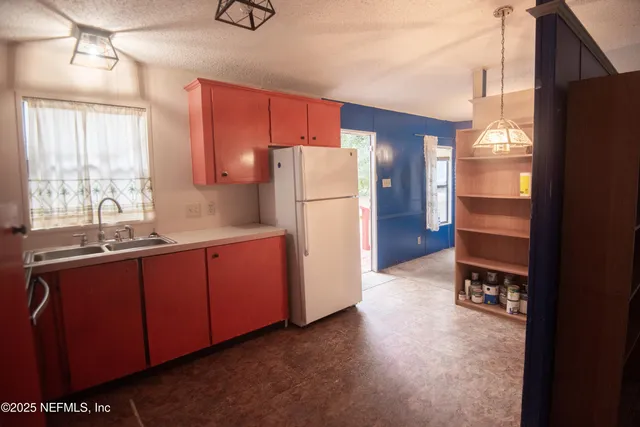 a kitchen with a refrigerator and a sink