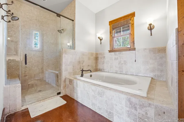 a spacious bathroom with a granite countertop tub shower and mirror
