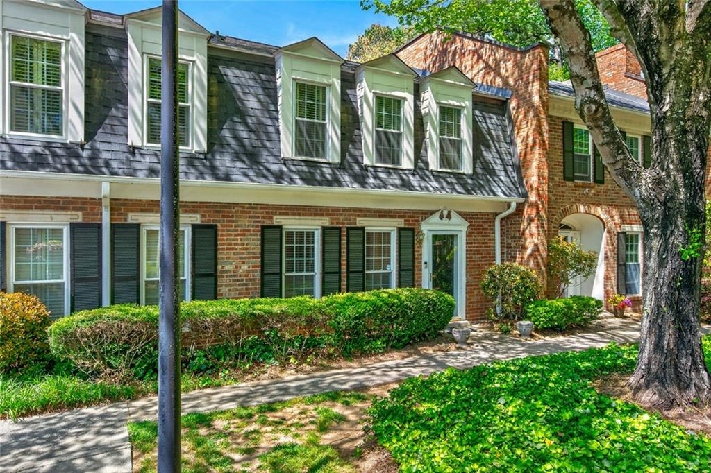 front view of a brick house with a yard