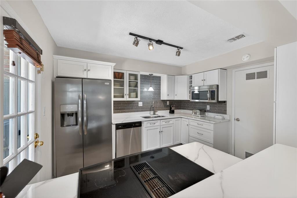 9 Scotland Place Northwest Atlanta, GA 30318 - Photo 15 of 49 a kitchen with stainless steel appliances kitchen island granite countertop a refrigerator sink and stove