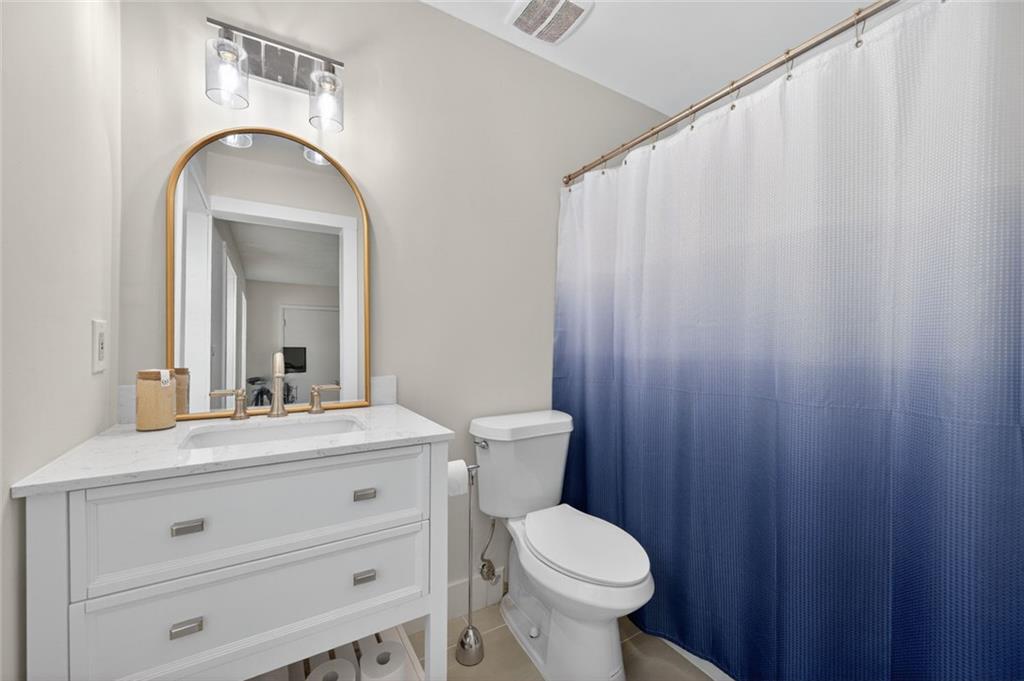 9 Scotland Place Northwest Atlanta, GA 30318 - Photo 27 of 49 a bathroom with a toilet a sink and mirror