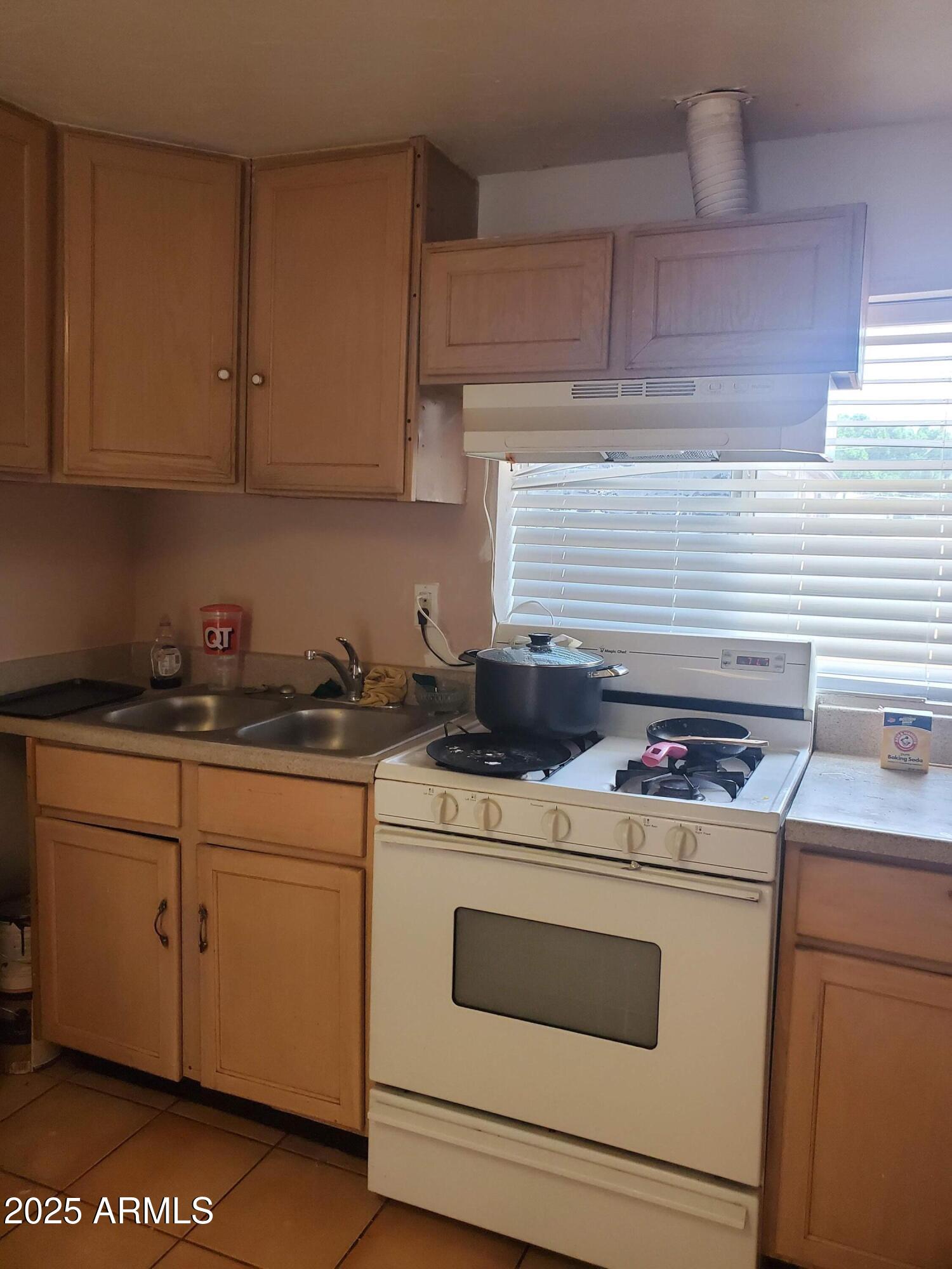 3041 East Osborn Road Phoenix, AZ 85016 - Photo 17 of 22 a kitchen with a stove and white cabinets