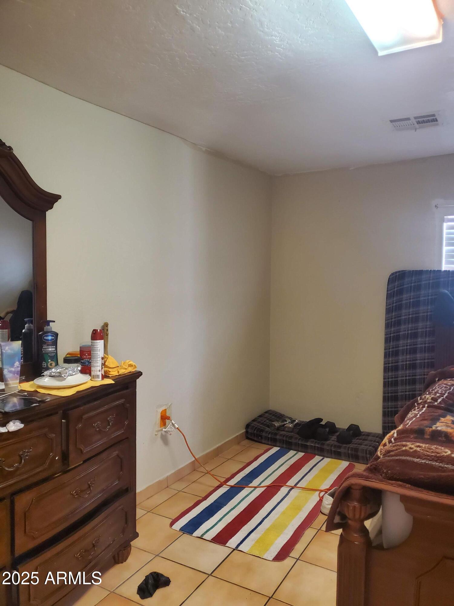 3041 East Osborn Road Phoenix, AZ 85016 - Photo 18 of 22 a room that has a bed and a table in it