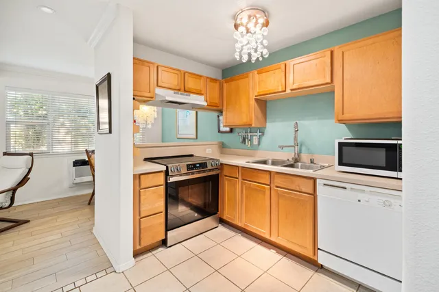 a kitchen with stainless steel appliances granite countertop a stove a sink and a refrigerator