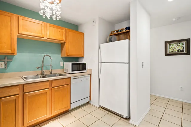 a kitchen with a refrigerator sink and cabinets