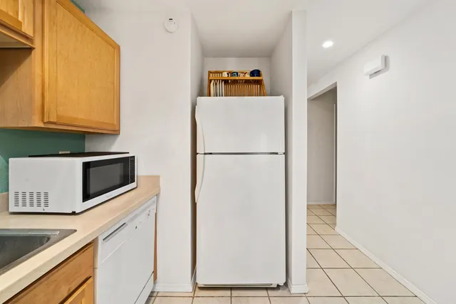 a white refrigerator freezer and a stove sitting inside of a kitchen