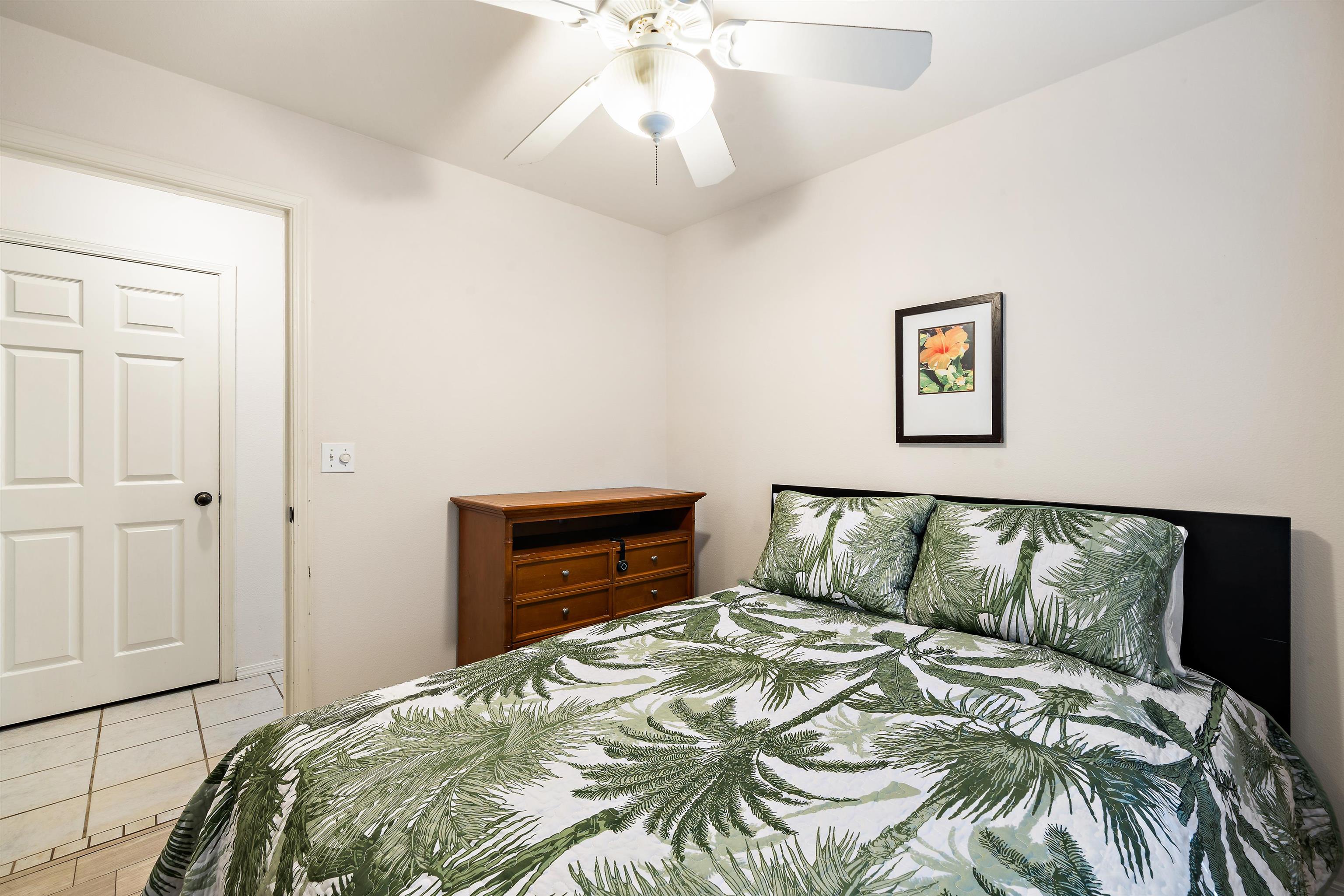 65 Halili Lane, Unit 10F Kihei, HI 96753 - Photo 25 of 48 a bedroom with a bed and a chandelier