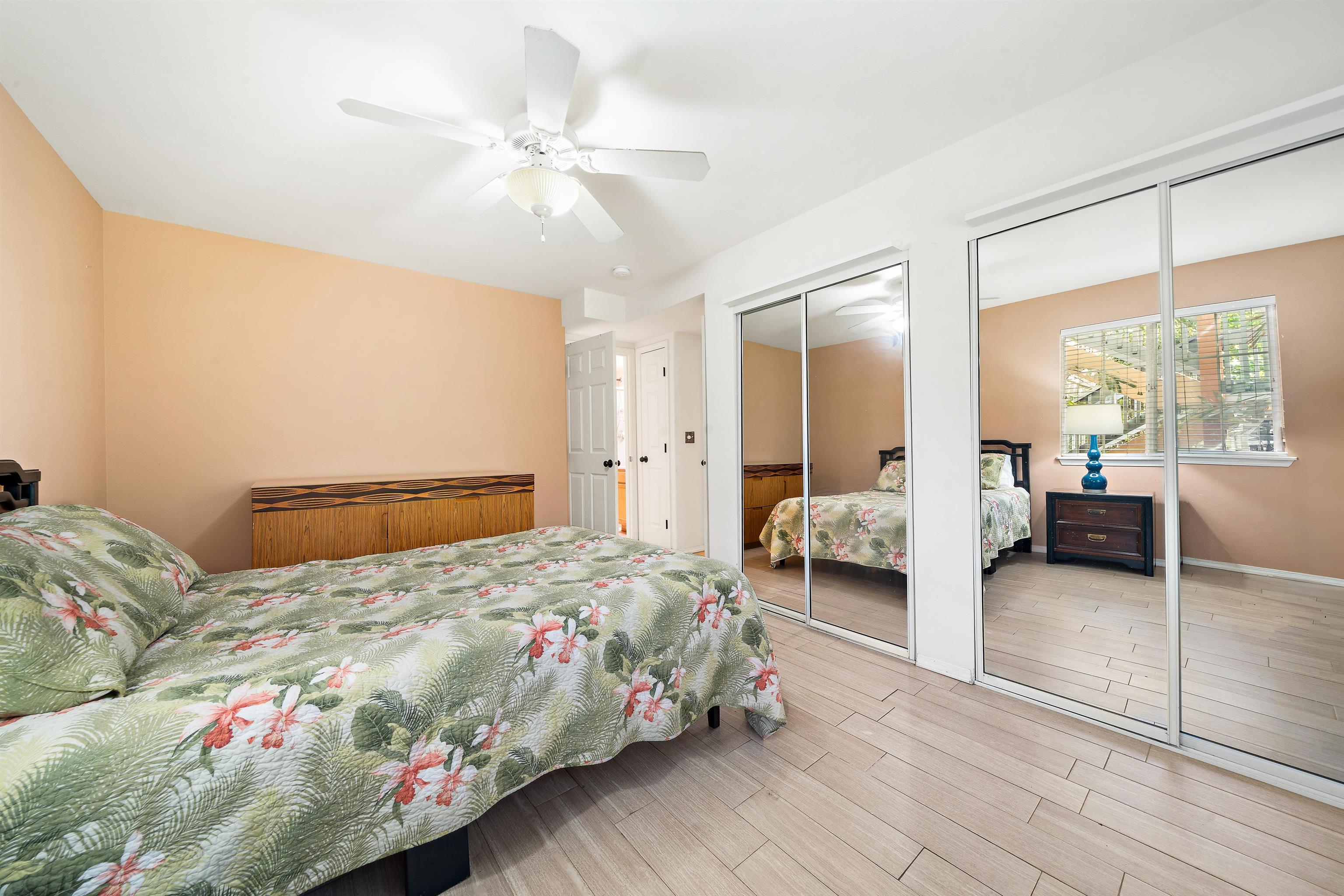 65 Halili Lane, Unit 10F Kihei, HI 96753 - Photo 33 of 48 a bedroom with a large bed and a chandelier