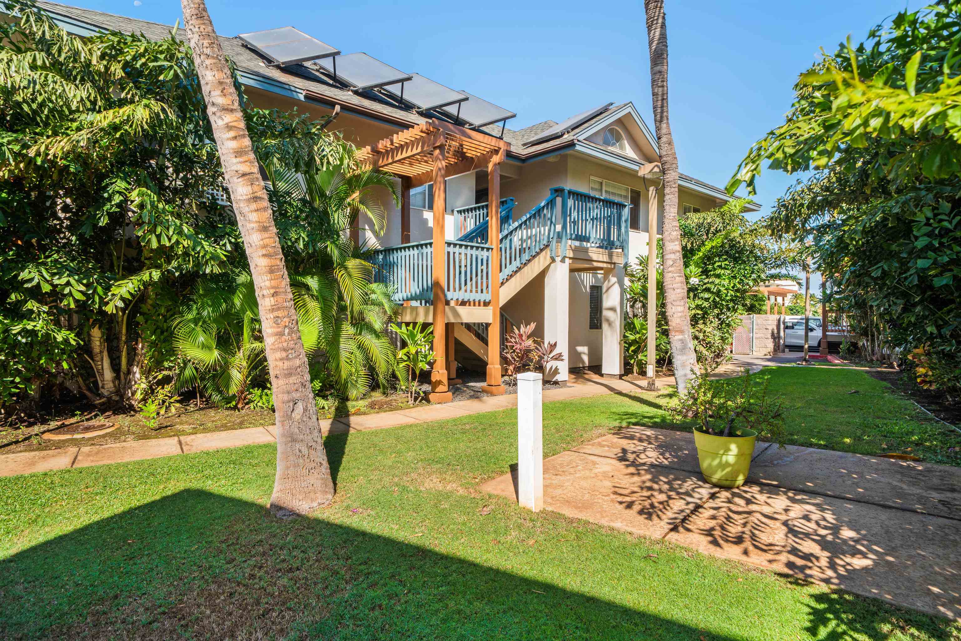 65 Halili Lane, Unit 10F Kihei, HI 96753 - Photo 38 of 48 a front view of a house with a yard fountain and a tree