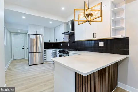 a kitchen with a refrigerator a sink and dishwasher with wooden floor