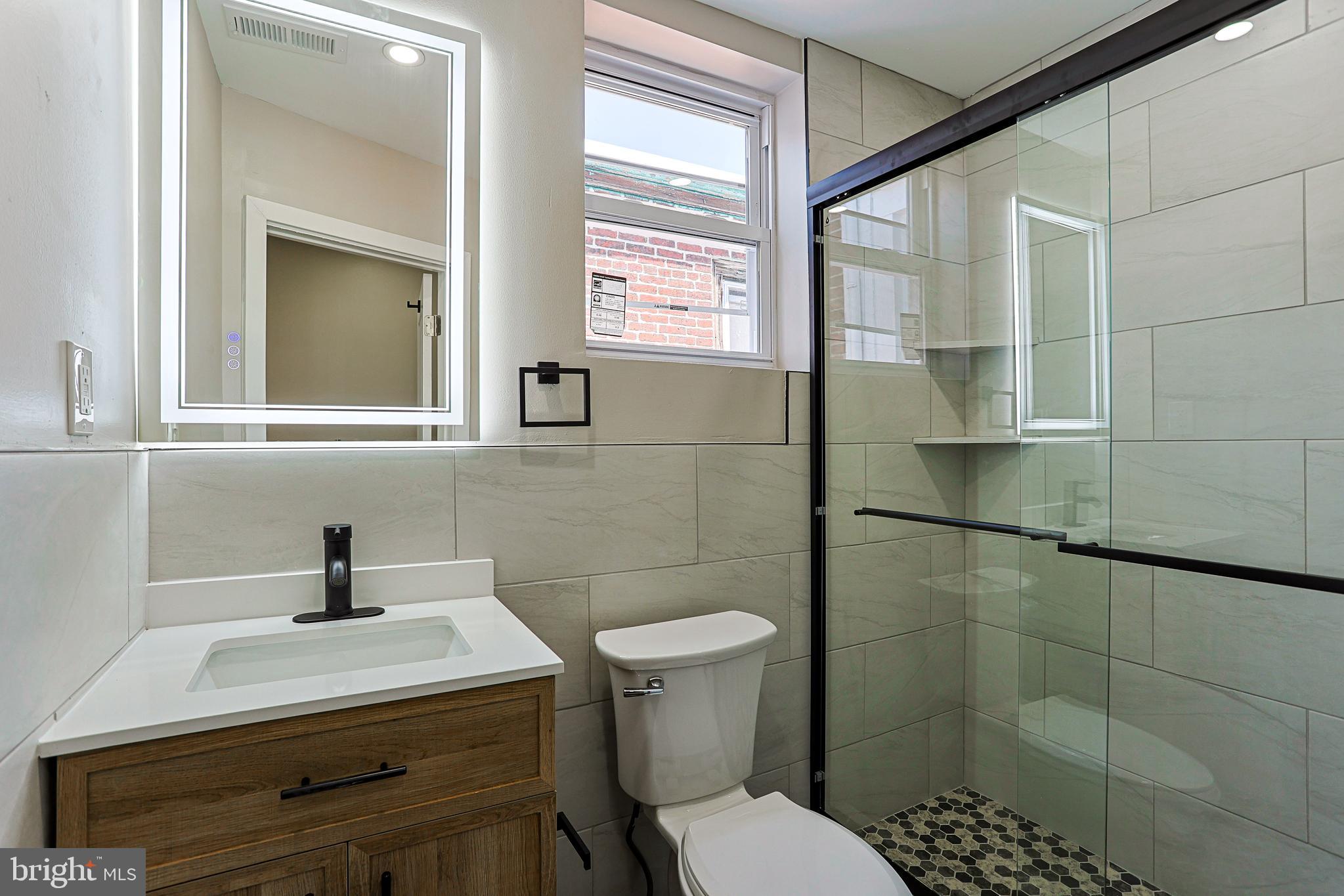 2129 East Tioga Street Philadelphia, PA 19134 - Photo 16 of 32 a bathroom with a sink a toilet and shower