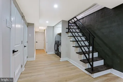 a view of a hallway with wooden floor and staircase