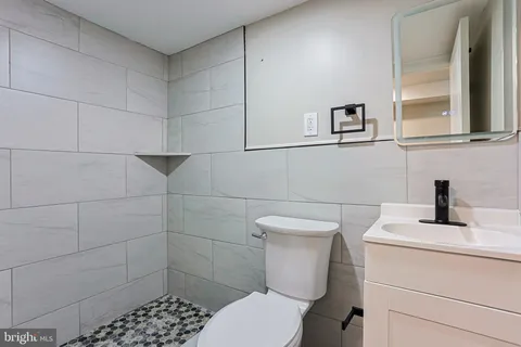 a bathroom with a toilet sink and mirror