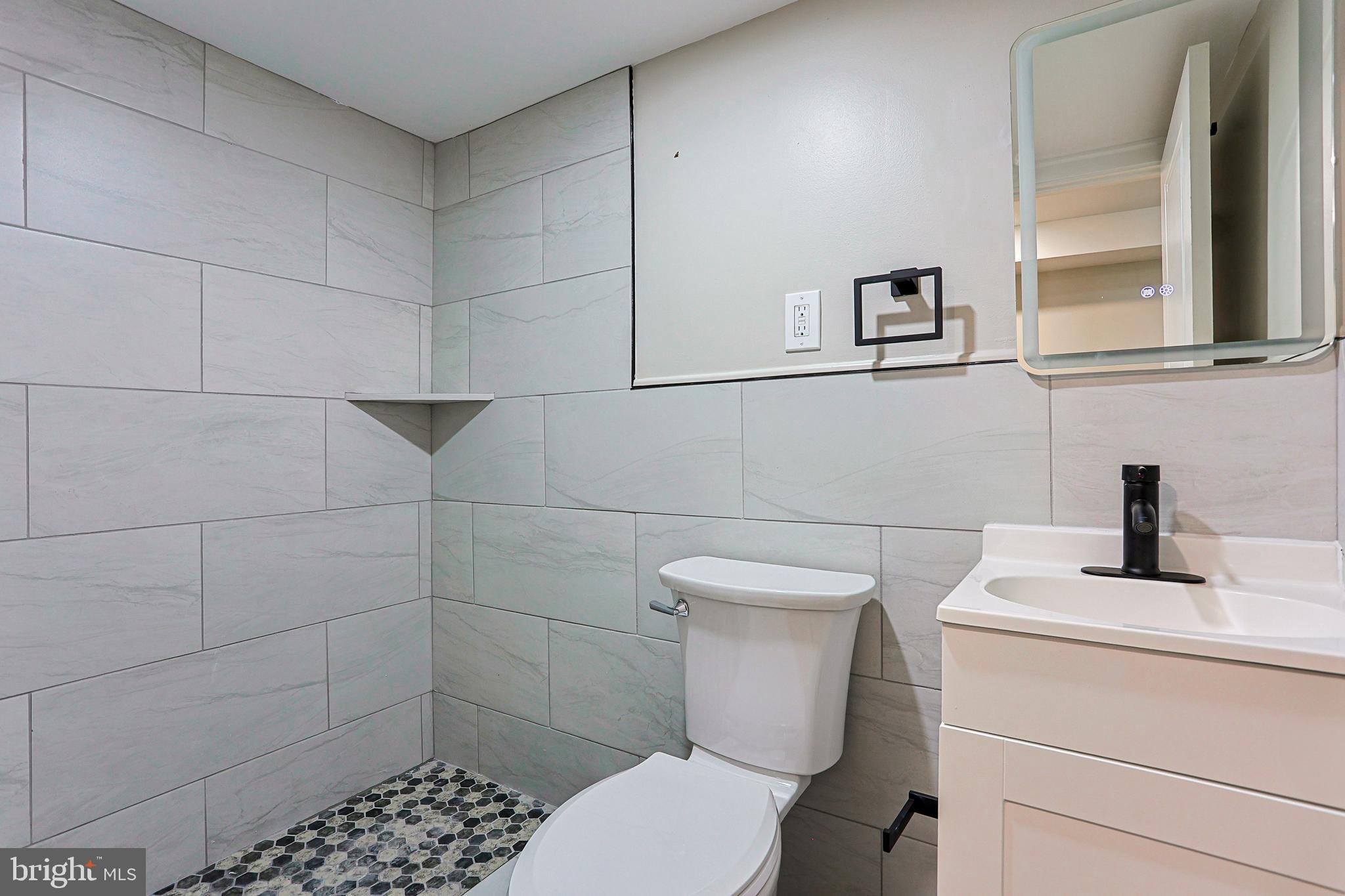 2129 East Tioga Street Philadelphia, PA 19134 - Photo 26 of 32 a bathroom with a toilet sink and mirror