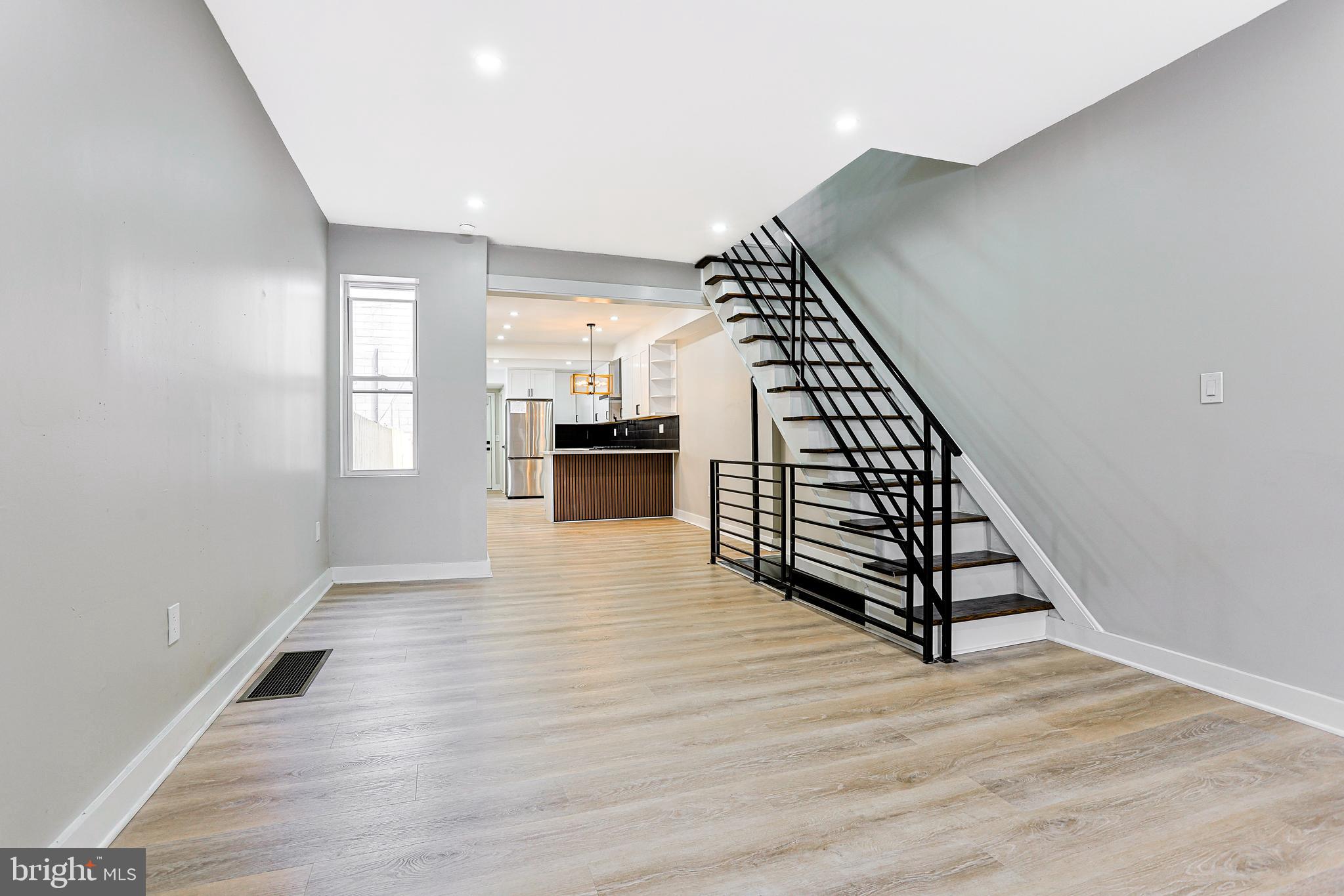 2129 East Tioga Street Philadelphia, PA 19134 - Photo 9 of 32 an empty room with wooden floor and staircase