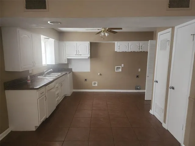 a large kitchen with a refrigerator a sink and cabinets