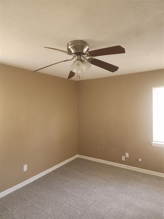 3454 Guadalupe Road Fort Worth, TX 76116 - Photo 15 of 21 Empty room featuring carpet floors, a ceiling fan, and a textured ceiling