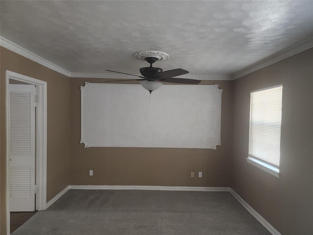 3454 Guadalupe Road Fort Worth, TX 76116 - Photo 5 of 21 Carpeted spare room featuring crown molding, ceiling fan, and a textured ceiling