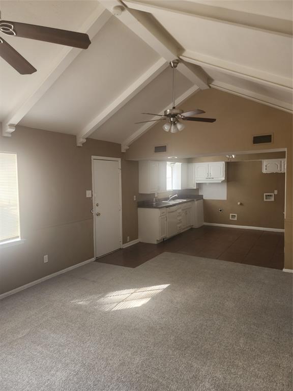 3454 Guadalupe Road Fort Worth, TX 76116 - Photo 7 of 21 Unfurnished living room with a ceiling fan, dark colored carpet, and vaulted ceiling