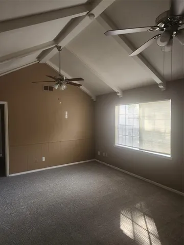 an empty room with a ceiling fan and window