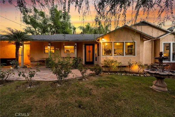 a view of house with backyard and outdoor seating