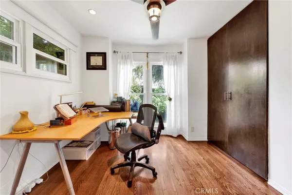 a view of a workspace with furniture and a window