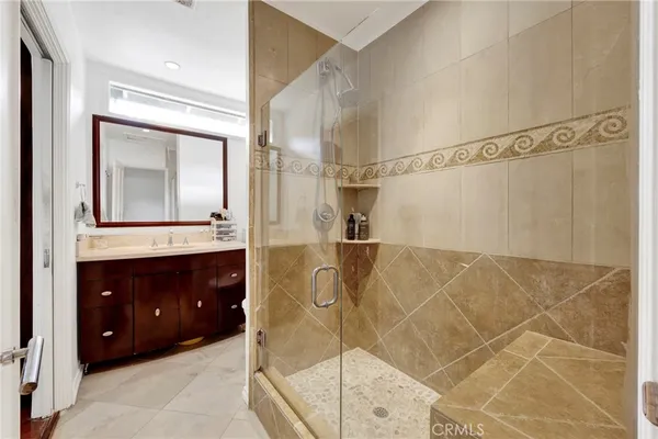 a bathroom with a sink vanity and shower