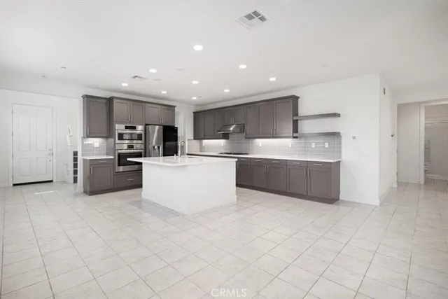 a kitchen with stainless steel appliances a refrigerator sink and cabinets