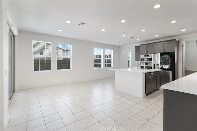 a large white kitchen with kitchen island granite countertop lots of white stainless steel appliances