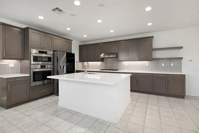 a kitchen with kitchen island counter top space cabinets and stainless steel appliances