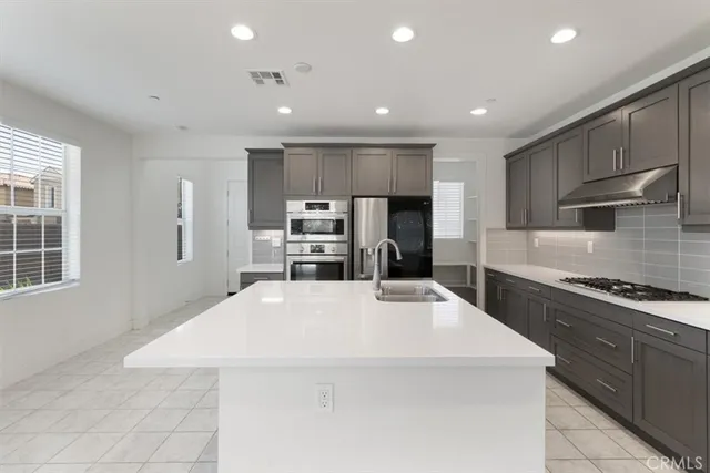 a large kitchen with stainless steel appliances and large cabinets
