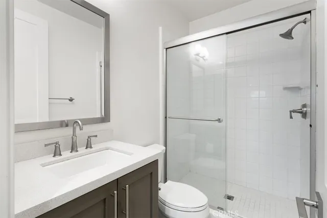 a bathroom with a sink mirror toilet and shower