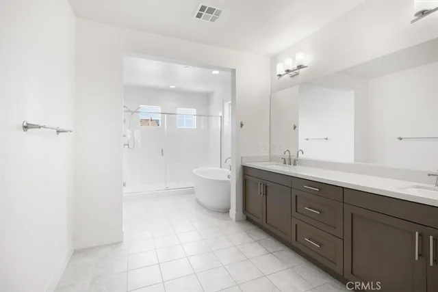 a spacious bathroom with a double vanity sink toilet mirror and bathtub